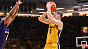 Feb 22, 2025; Iowa City, Iowa, USA; Iowa Hawkeyes guard Josh Dix (4) shoots the ball over Washington Huskies guard Mekhi Mason (0) during the second half at Carver-Hawkeye Arena. Mandatory Credit: Jeffrey Becker-Imagn Images
