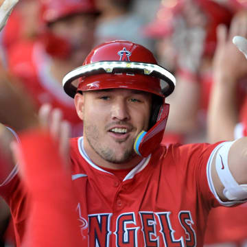 Apr 9, 2024; Anaheim, California, USA;  Los Angeles Angels outfielder Mike Trout (27) celebrates in the dugout after hitting a two run home run in the first inning against the Tampa Bay Rays at Angel Stadium. Mandatory Credit: Jayne Kamin-Oncea-USA TODAY Sports