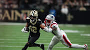 Oct 12, 2025; New Orleans, Louisiana, USA; New Orleans Saints wide receiver Chris Olave (12) runs for a gain past New England Patriots safety Craig Woodson (31) during the second quarter at Caesars Superdome. Mandatory Credit: Matthew Hinton-Imagn Images