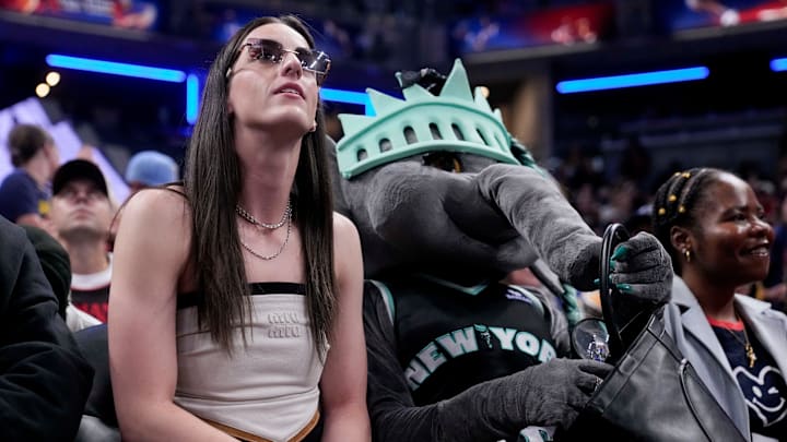 Indiana Fever's Caitlin Clark sits with New York Liberty mascot Ellie the Elephant ahead of the WNBA All-Star 3-point and skills contests at Gainbridge Fieldhouse in Indianapolis.