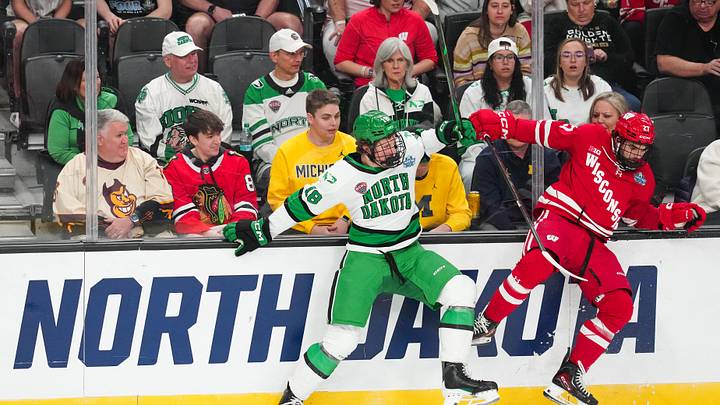 Apr 9, 2026; Las Vegas, Nevada, UNITED STATES; North Dakota Fighting Hawks defenseman Keaton Verhoeff (18) is checked by Wisconsin Badgers forward Finn Brink (27) in the first period in the semifinals of the NCAA men's ice hockey Frozen Four at T-Mobile Arena. Mandatory Credit: Stephen R. Sylvanie-Imagn Images
