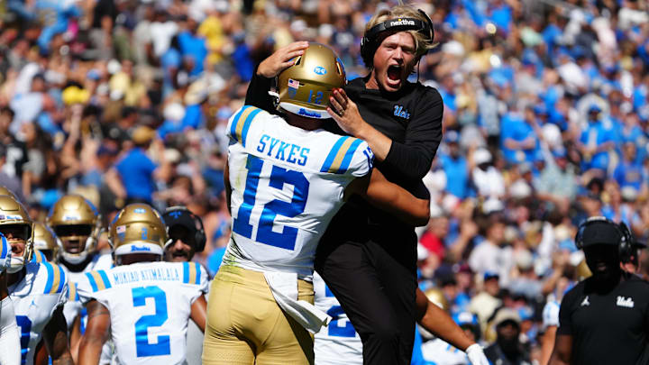 Sep 24, 2022; Boulder, Colorado, USA; UCLA Bruins wide receiver coach Jerry Neuheisel and wide receiver Matt Sykes (12) celebrate a touchdown in the first quarter at Folsom Field. Mandatory Credit: Ron Chenoy-Imagn Images