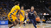 Feb 1, 2025; Milwaukee, Wisconsin, USA;  Connecticut Huskies guard Solo Ball (1) drives for the basket against Marquette Golden Eagles forward Royce Parham (13) during the first half at Fiserv Forum. Mandatory Credit: Jeff Hanisch-Imagn Images