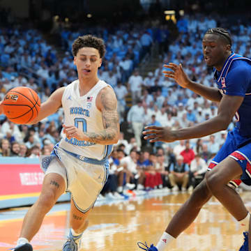 Nov 7, 2025; Chapel Hill, North Carolina, USA;  North Carolina Tar Heels guard Kyan Evans (0) with the ball as Kansas Jayhawks forward Flory Bidunga (40) defends in the second half at Dean E. Smith Center. 