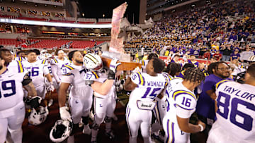 Oct 19, 2024; Fayetteville, Arkansas, USA; LSU Tigers players lift The Golden Boot trophy after a game against the Arkansas Razorbacks at Donald W. Reynolds Razorback Stadium. LSU won 34-10. Mandatory Credit: Nelson Chenault-Imagn Images