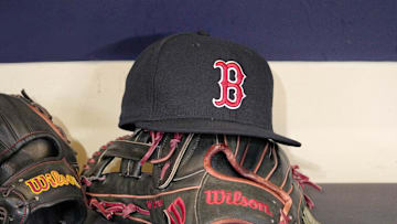 May 27, 2025; Milwaukee, Wisconsin, USA; A Boston Red Sox hat and glove sit in the dug out before a game against the Milwaukee Brewers at American Family Field. Mandatory Credit: Michael McLoone-Imagn Images