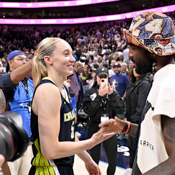 Dallas Mavericks point guard Irving talks with Dallas Wings guard Bueckers after the game against the Indiana Fever at the American Airlines Center. 