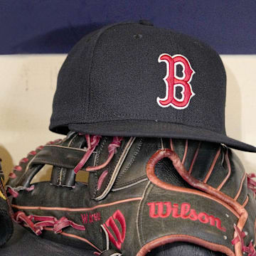 May 27, 2025; Milwaukee, Wisconsin, USA; A Boston Red Sox hat and glove sit in the dug out before a game against the Milwaukee Brewers at American Family Field. Mandatory Credit: Michael McLoone-Imagn Images