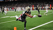 Oct 12, 2025; New Orleans, Louisiana, USA; New Orleans Saints wide receiver Chris Olave (12) misses a touchdown pass under pressure from New England Patriots cornerback Marcus Jones (25) during the second quarter at Caesars Superdome. Mandatory Credit: Matthew Hinton-Imagn Images