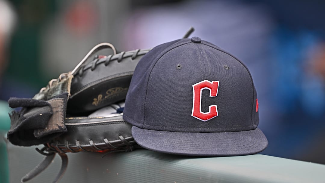 Jun 27, 2024; Kansas City, Missouri, USA; A general view a Cleveland Guardians hat and glove on the dugout railing  before a game against the Kansas City Royals at Kauffman Stadium. Mandatory Credit: Peter Aiken-Imagn Images