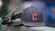Jun 27, 2024; Kansas City, Missouri, USA; A general view a Cleveland Guardians hat and glove on the dugout railing  before a game against the Kansas City Royals at Kauffman Stadium. Mandatory Credit: Peter Aiken-Imagn Images
