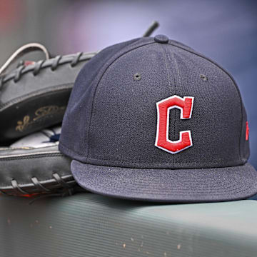 Jun 27, 2024; Kansas City, Missouri, USA; A general view a Cleveland Guardians hat and glove on the dugout railing  before a game against the Kansas City Royals at Kauffman Stadium. Mandatory Credit: Peter Aiken-Imagn Images