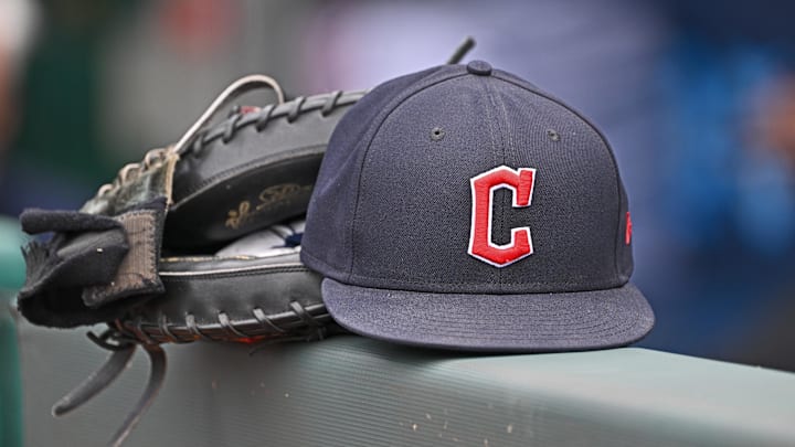 Jun 27, 2024; Kansas City, Missouri, USA; A general view a Cleveland Guardians hat and glove on the dugout railing  before a game against the Kansas City Royals at Kauffman Stadium. Mandatory Credit: Peter Aiken-Imagn Images