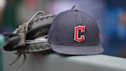 Jun 27, 2024; Kansas City, Missouri, USA; A general view a Cleveland Guardians hat and glove on the dugout railing  before a game against the Kansas City Royals at Kauffman Stadium. Mandatory Credit: Peter Aiken-Imagn Images
