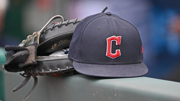 Jun 27, 2024; Kansas City, Missouri, USA; A general view a Cleveland Guardians hat and glove on the dugout railing  before a game against the Kansas City Royals at Kauffman Stadium. Mandatory Credit: Peter Aiken-USA TODAY Sports