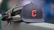 Jun 27, 2024; Kansas City, Missouri, USA; A general view a Cleveland Guardians hat and glove on the dugout railing  before a game against the Kansas City Royals at Kauffman Stadium. Mandatory Credit: Peter Aiken-Imagn Images