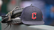 Jun 27, 2024; Kansas City, Missouri, USA; A general view a Cleveland Guardians hat and glove on the dugout railing  before a game against the Kansas City Royals at Kauffman Stadium. Mandatory Credit: Peter Aiken-Imagn Images