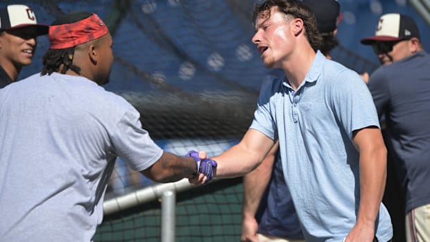 Travis Bazzana, right, shakes hands with third baseman Jose Ramirez (11)