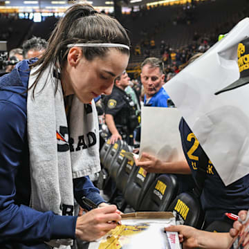 May 4, 2025; Iowa City, IA, USA; Indiana Fever guard Caitlin Clark (22) signs autographs for fans after the game against the Brazil National Team at Carver-Haweye Arena. Mandatory Credit: Jeffrey Becker-Imagn Images