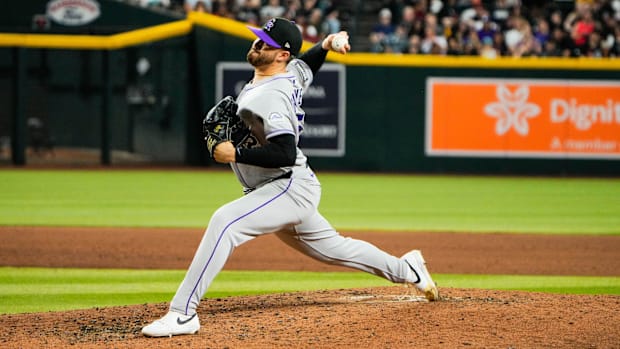 Colorado Rockies pitcher Dugan Darnell throws a pitch off the mound, wearing a gray jersey and a black hat.