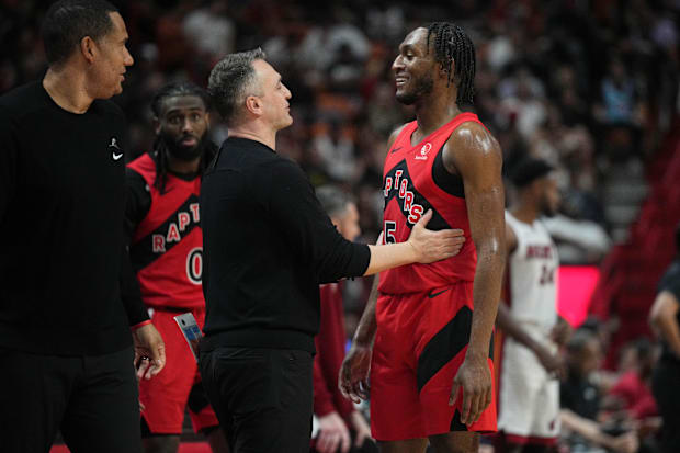 Toronto Raptors head coach Darko Rajakovic shares a laugh with guard Immanuel Quickley (5) during an NBA game vs. Miami Heat.