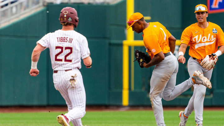 Jun 19, 2024; Omaha, NE, USA; Florida State Seminoles right fielder James Tibbs III (22) is tagged out at second by Tennessee Volunteers second baseman Christian Moore (1) during the sixth inning at Charles Schwab Field Omaha.