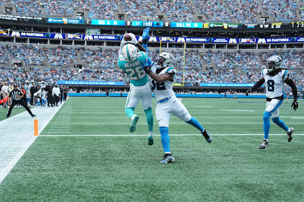 Dolphins running back De'Von Achane (28) catches a touchdown pass as Panthers linebacker Trevin Wallace (32) defends.