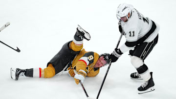 Mar 9, 2025; Las Vegas, Nevada, USA; Los Angeles Kings center Anze Kopitar (11) takes the puck from a fallen Vegas Golden Knights center Jack Eichel (9) during the third period at T-Mobile Arena. Mandatory Credit: Stephen R. Sylvanie-Imagn Images