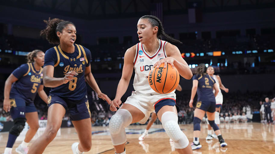 UConn Huskies guard Azzi Fudd controls the ball as Notre Dame Fighting Irish guard Cassandre Prosper defends.