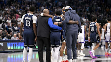 Mar 3, 2025; Dallas, Texas, USA; Dallas Mavericks guard Kyrie Irving (11) is helped off the court by forward Naji Marshall (13) and forward Anthony Davis (3) during the second quarter against the Sacramento Kings at the American Airlines Center. Mandatory Credit: Jerome Miron-Imagn Images