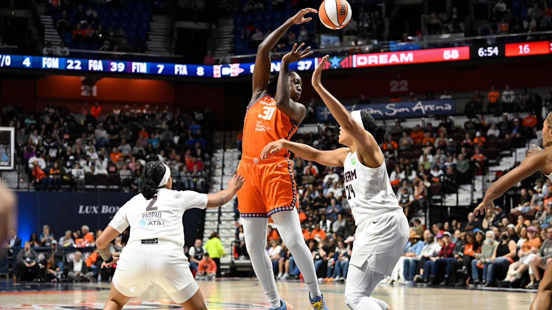 Sep 10, 2025; Uncasville, Connecticut, USA; Connecticut Sun center Tina Charles (31) passes the ball against Atlanta Dream forward Brionna Jones (24) and guard Te-Hina Paopao (2) during the second half at Mohegan Sun Arena.