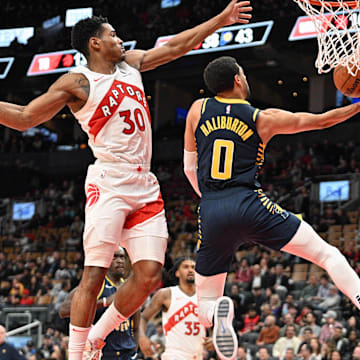 Apr 9, 2024; Toronto, Ontario, CAN;  Indiana Pacers guard Tyrese Haliburton (0) scores on a reverse layup against Toronto Raptors guard Ochai Agbaji (30) in the second half at Scotiabank Arena. Mandatory Credit: Dan Hamilton-Imagn Images