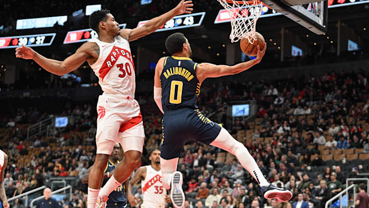 Apr 9, 2024; Toronto, Ontario, CAN;  Indiana Pacers guard Tyrese Haliburton (0) scores on a reverse layup against Toronto Raptors guard Ochai Agbaji (30) in the second half at Scotiabank Arena. Mandatory Credit: Dan Hamilton-Imagn Images