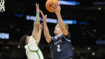 Mar 21, 2025; Seattle, WA, USA; Liberty Flames guard Taelon Peter (2) shoots the ball over Oregon Ducks guard Ra'Heim Moss (0) during the second half in the first round of the NCAA Tournament  at Climate Pledge Arena.