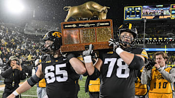 Nov 2, 2024; Iowa City, Iowa, USA; Iowa Hawkeyes offensive lineman Logan Jones (65) and offensive lineman Mason Richman (78) carry the Heartland trophy after the game against the Wisconsin Badgers at Kinnick Stadium. Mandatory Credit: Jeffrey Becker-Imagn Images