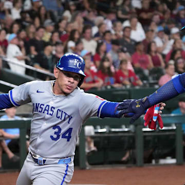Jul 4, 2025; Phoenix, Arizona, USA; Kansas City Royals catcher Freddy Fermin (34) slaps hands with Kansas City Royals first base Vinnie Pasquantino (9) after scoring a run against the Arizona Diamondbacks during the second inning at Chase Field. Mandatory Credit: Joe Camporeale-Imagn Images