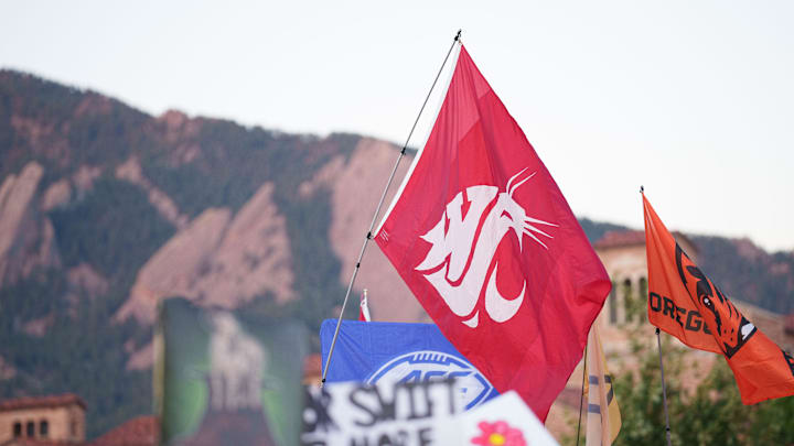 A fan holds a Washington State University flag on the set of ESPN College GameDay