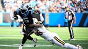 Nov 9, 2025; Charlotte, North Carolina, USA;  Carolina Panthers running back Rico Dowdle (5) rushes as New Orleans Saints linebacker Demario Davis (56) tackles during the third quarter at Bank of America Stadium. Mandatory Credit: Bob Donnan-Imagn Images