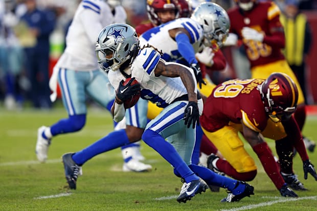 Dallas Cowboys wide receiver KaVontae Turpin breaks a tackle by Washington Commanders safety Jeremy Reaves.
