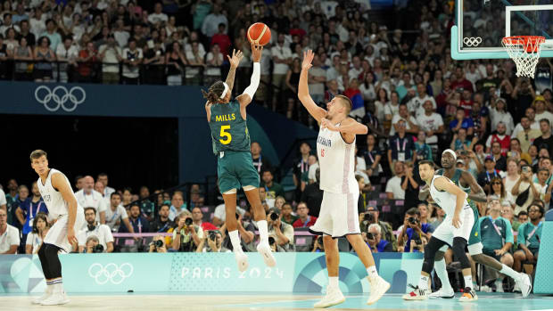 Australia guard Patty Mills (5) shoots the game tying shot against Serbia power forward Nikola Jokic (15) with second left du