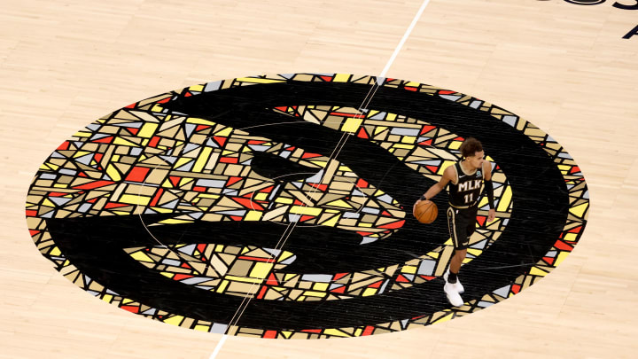 Jan 18, 2021; Atlanta, Georgia, USA; Atlanta Hawks guard Trae Young (11) dribbles up the court over the Atlanta Hawks logo in the second half against the Minnesota Timberwolves at State Farm Arena. Mandatory Credit: Jason Getz-USA TODAY Sports