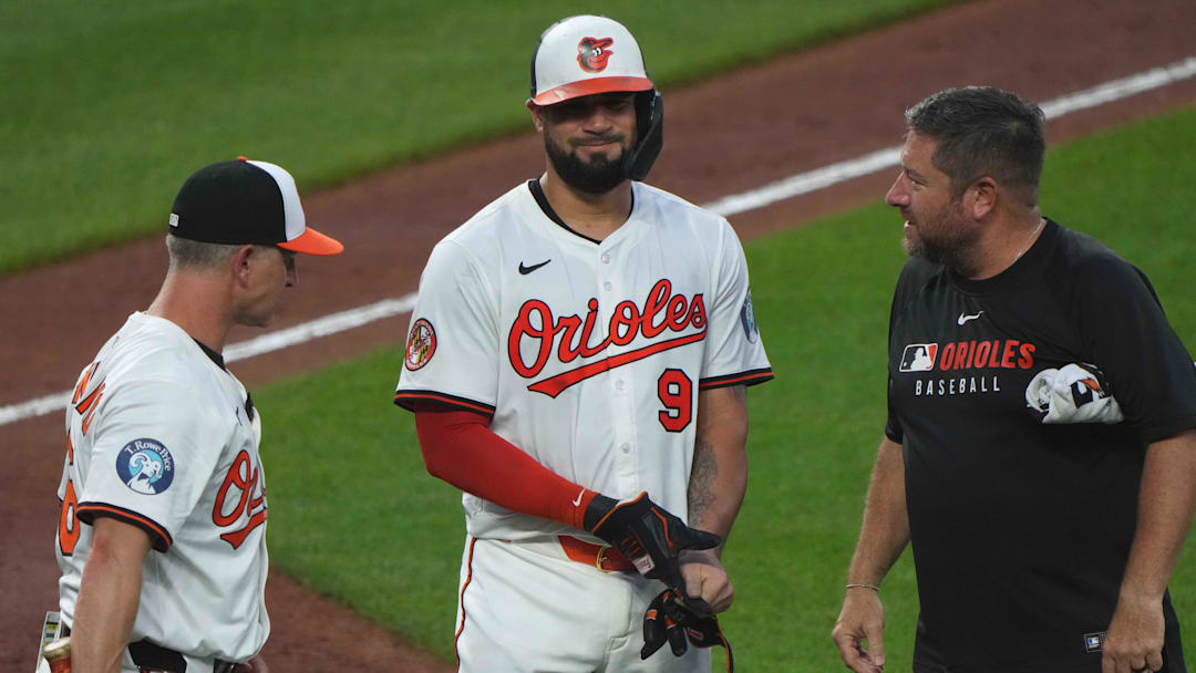Jun 23, 2025; Baltimore, Maryland, USA; Baltimore Orioles designated hitter Gary Sanchez (99) is visited by manager Tony Mansolino (left) and training staff (right) after being hit by a pitch during the seventh inning against the Texas Rangers at Oriole Park at Camden Yards. 