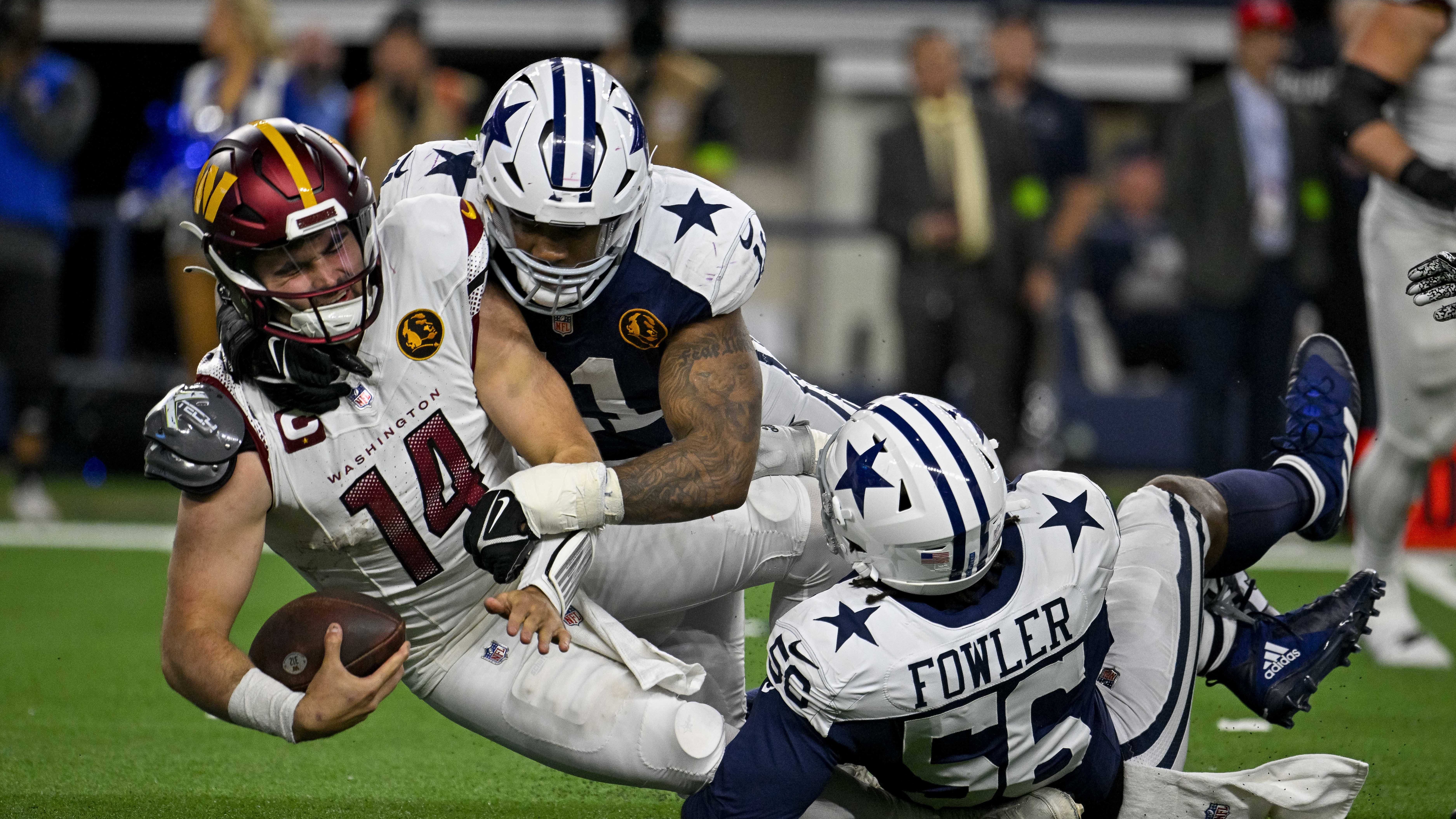 Cowboys pass rusher Micah Parsons, center, sacks Commanders QB Sam Howell.