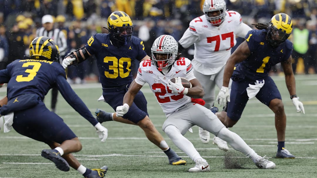 Ohio State Buckeyes running back Bo Jackson runs the ball pressured by Michigan Wolverines linebacker Jimmy Rolder and defensive back Jaden Mangham