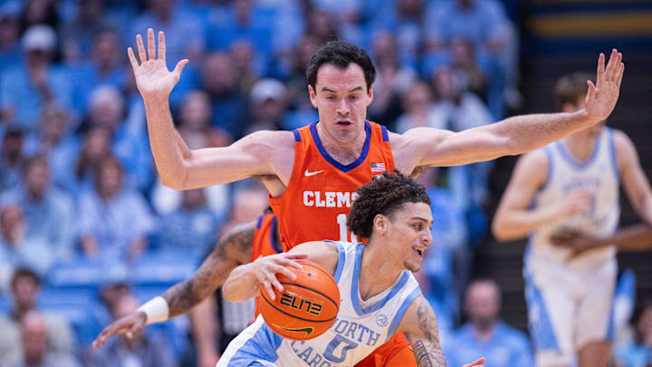 Mar 3, 2026; Chapel Hill, North Carolina, USA; North Carolina Tar Heels guard Kyan Evans (0) dribbles around Clemson Tigers forward Nick Davidson (11) during the first half at Dean E. Smith Center. Mandatory Credit: Scott Kinser-Imagn Images