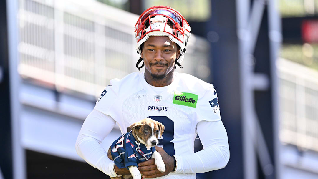 Jul 23, 2025; Foxborough, MA, USA; New England Patriots wide receiver Stefon Diggs (8) delivers a puppy to a local family as part of the Patriots pet adoption event before training camp at Gillette Stadium. Mandatory Credit: Eric Canha-Imagn Images