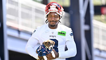 Jul 23, 2025; Foxborough, MA, USA; New England Patriots wide receiver Stefon Diggs (8) delivers a puppy to a local family as part of the Patriots pet adoption event before training camp at Gillette Stadium. Mandatory Credit: Eric Canha-Imagn Images