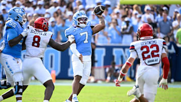 Sep 13, 2025; Chapel Hill, North Carolina, USA; North Carolina Tar Heels quarterback Gio Lopez (7) passes the ball as Richmond Spiders defensive lineman Donovan Hoilette (8) and defensive back Devin Geronomi (22) pressure in the second quarter at Kenan Stadium. Mandatory Credit: Bob Donnan-Imagn Images