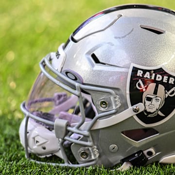 A Las Vegas Raiders helmet sits on the field before the game against the Minnesota Vikings at U.S. Bank Stadium.