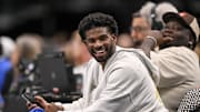 Jan 14, 2025; Dallas, Texas, USA; Colorado Buffaloes quarterback Shedeur Sanders laughs as he watches the game between the Dallas Mavericks and the Denver Nuggets during the second half at the American Airlines Center. Mandatory Credit: Jerome Miron-Imagn Images